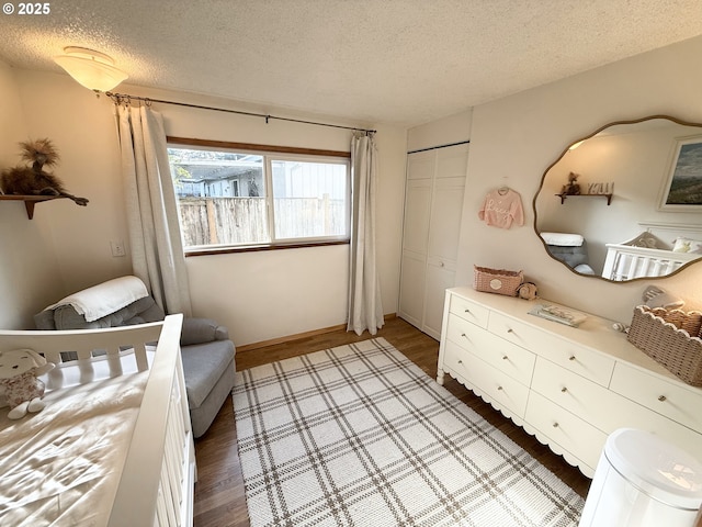 bedroom with a closet, wood finished floors, and a textured ceiling