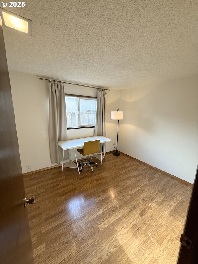 home office with wood finished floors and a textured ceiling