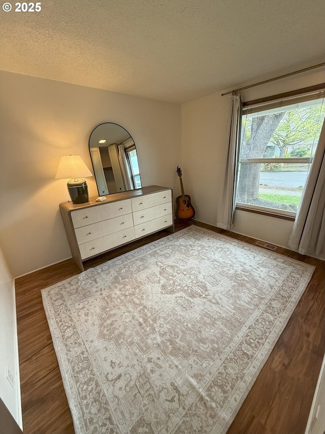 unfurnished bedroom featuring a textured ceiling and wood finished floors