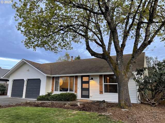 single story home featuring roof with shingles, a garage, and aphalt driveway
