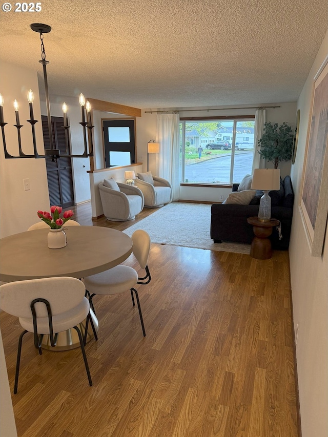 dining space with wood finished floors and a textured ceiling