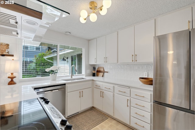 3138 Kentwood Dr, Eugene, OR 97401 - kitchen with stainless steel appliances, a sink, light countertops, a textured ceiling, and backsplash