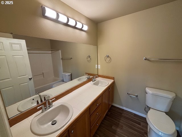 bathroom featuring shower / bathing tub combination, wood-type flooring, and toilet