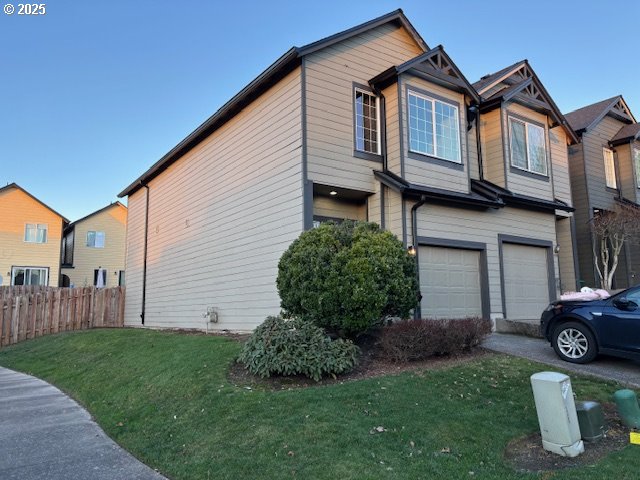 view of property exterior featuring a garage and a lawn