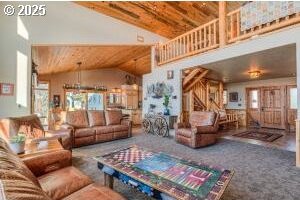 living room featuring high vaulted ceiling and stairs