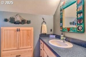 bathroom with vaulted ceiling and vanity