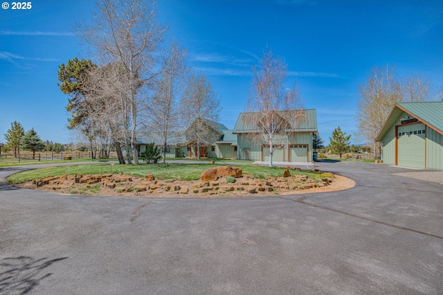 52995 Riverview Dr, La Pine, OR 97739 - view of front facade with metal roof, driveway, a front yard, and board and batten siding
