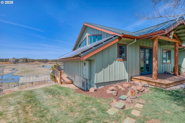 52995 Riverview Dr, La Pine, OR 97739 - view of side of property featuring french doors, board and batten siding, metal roof, and a lawn