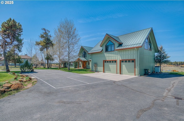 52995 Riverview Dr, La Pine, OR 97739 - view of property exterior with a standing seam roof, board and batten siding, metal roof, a garage, and central air condition unit