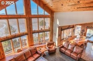 sunken living room with wooden ceiling, a high ceiling, and wood finished floors