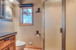 full bath featuring a stall shower, tile patterned flooring, vanity, and toilet