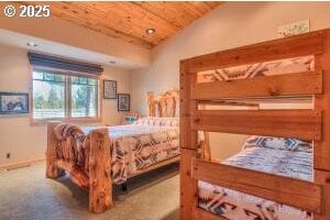 bedroom featuring lofted ceiling, wooden ceiling, and carpet flooring