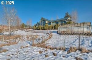 snowy yard featuring an outbuilding and an exterior structure