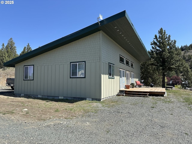 view of home's exterior with board and batten siding, crawl space, and a deck