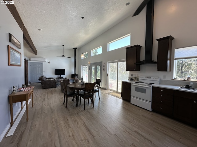 kitchen with ceiling fan, light wood-style floors, white range with electric cooktop, a textured ceiling, and open floor plan