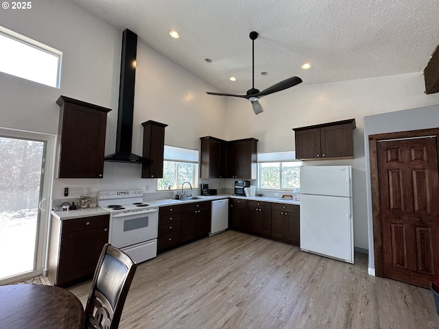kitchen with ceiling fan, a sink, light countertops, white appliances, and wall chimney exhaust hood
