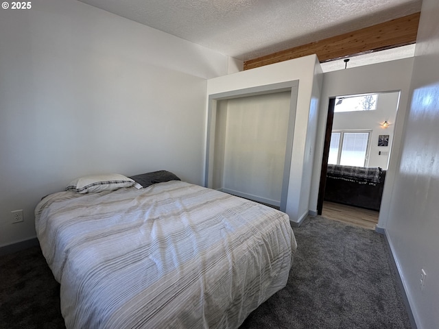 carpeted bedroom with baseboards and a textured ceiling