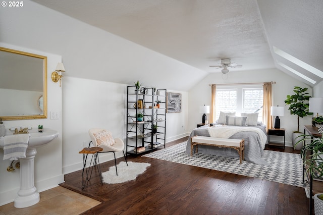 bedroom with ceiling fan, hardwood / wood-style floors, a textured ceiling, and vaulted ceiling