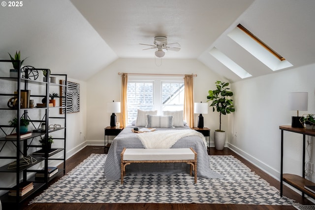 bedroom featuring ceiling fan, vaulted ceiling with skylight, and dark hardwood / wood-style floors