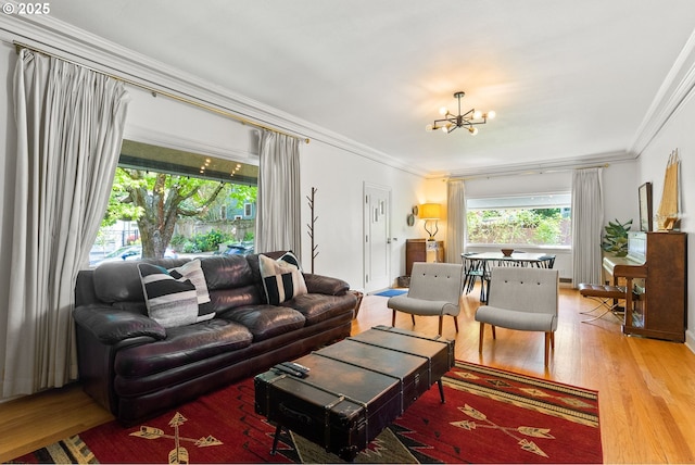 living room with a chandelier, crown molding, and wood finished floors