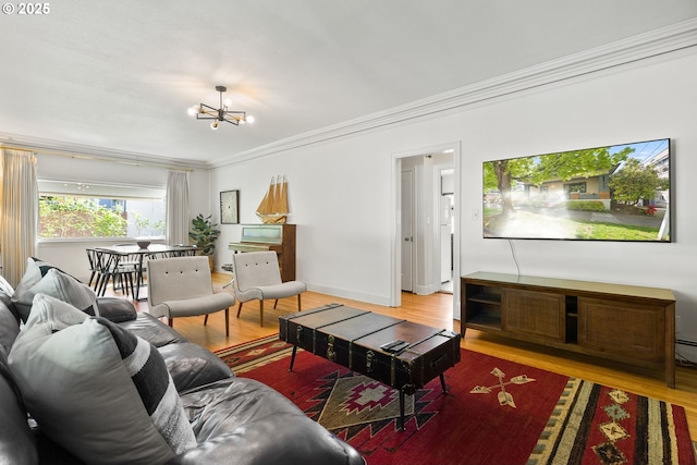 living area with crown molding, a chandelier, and wood finished floors