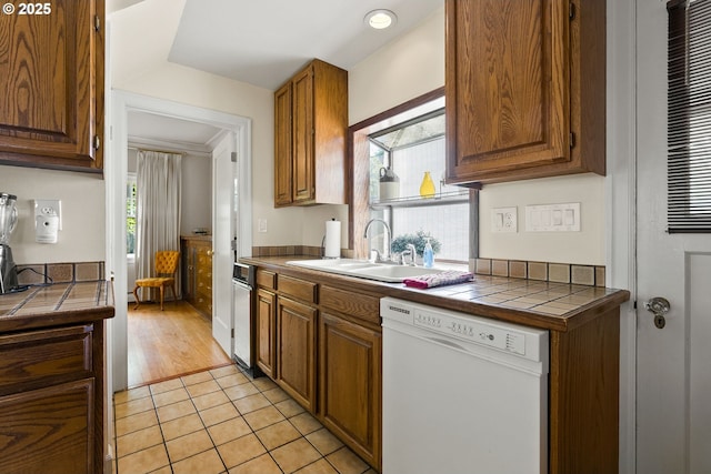 kitchen featuring dishwasher, healthy amount of natural light, and tile counters