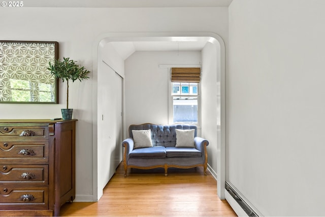sitting room with light wood-style floors, baseboards, and a baseboard radiator