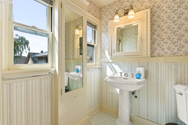 bathroom with wallpapered walls and tile patterned floors