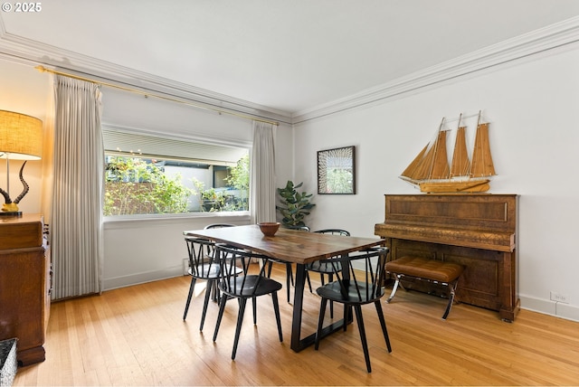 dining area with crown molding, light wood-style floors, and baseboards