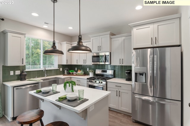 kitchen featuring white cabinetry, stainless steel appliances, and decorative light fixtures