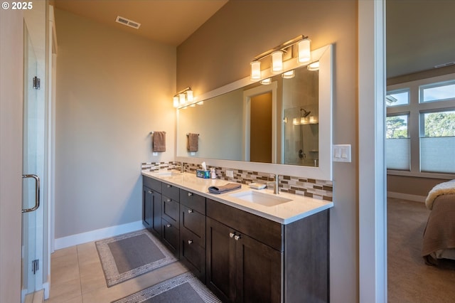 bathroom featuring vanity, an enclosed shower, tile patterned floors, and decorative backsplash