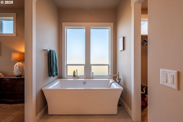 bathroom with a bathing tub and tile patterned flooring