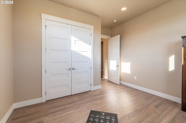 unfurnished bedroom featuring light hardwood / wood-style floors and a closet