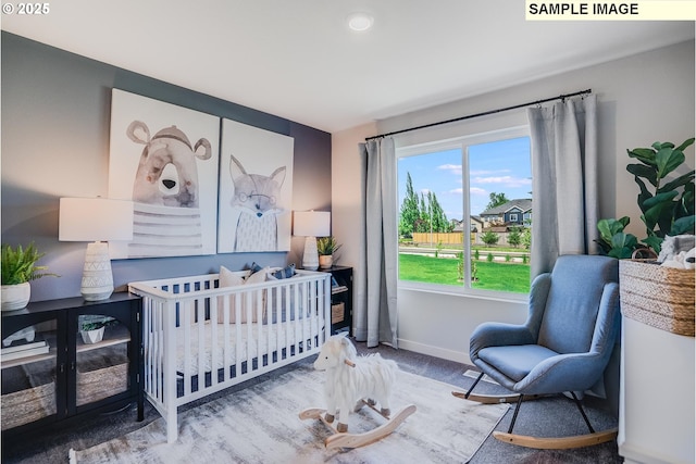 carpeted bedroom featuring a nursery area