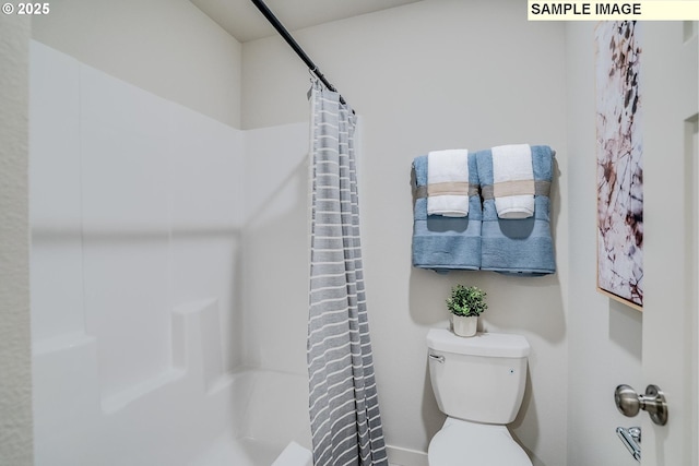 bathroom featuring walk in shower and toilet