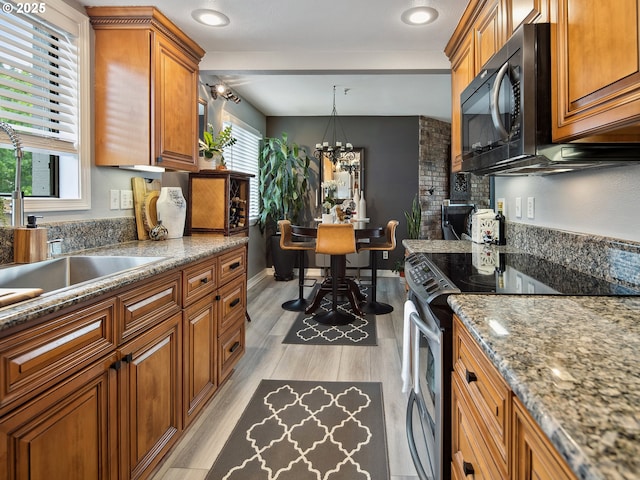 5535 E Evergreen Blvd Unit 7302, Vancouver, WA 98661 - kitchen with electric stove, black microwave, brown cabinetry, and light wood-style flooring