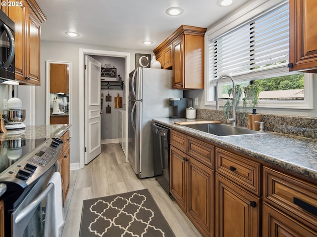 5535 E Evergreen Blvd Unit 7302, Vancouver, WA 98661 - kitchen featuring black appliances, brown cabinetry, recessed lighting, light wood-style floors, and dark countertops