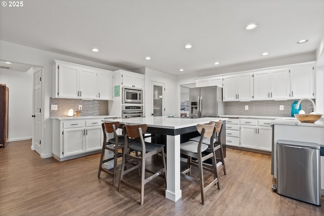 kitchen featuring light hardwood / wood-style flooring, stainless steel appliances, white cabinets, and sink