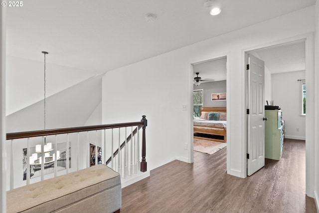 hallway with dark wood-type flooring and lofted ceiling