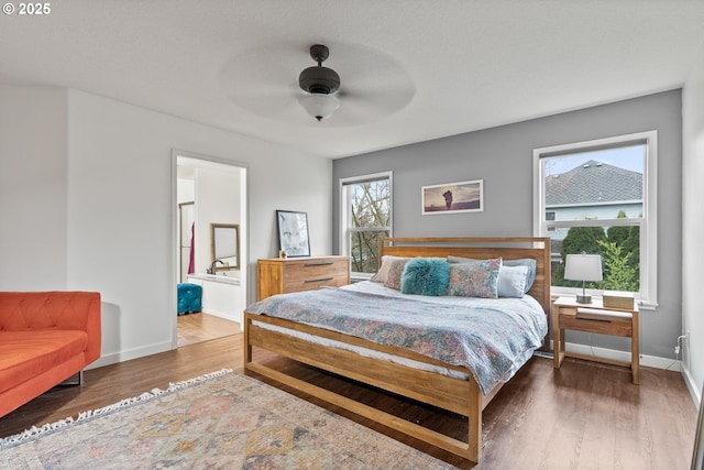 bedroom with ceiling fan, ensuite bathroom, and wood-type flooring