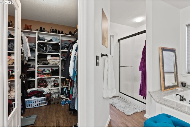 bathroom with hardwood / wood-style flooring, a textured ceiling, and walk in shower