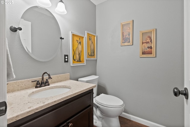 bathroom featuring toilet, wood-type flooring, and vanity