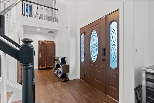 entrance foyer with a towering ceiling and hardwood / wood-style floors