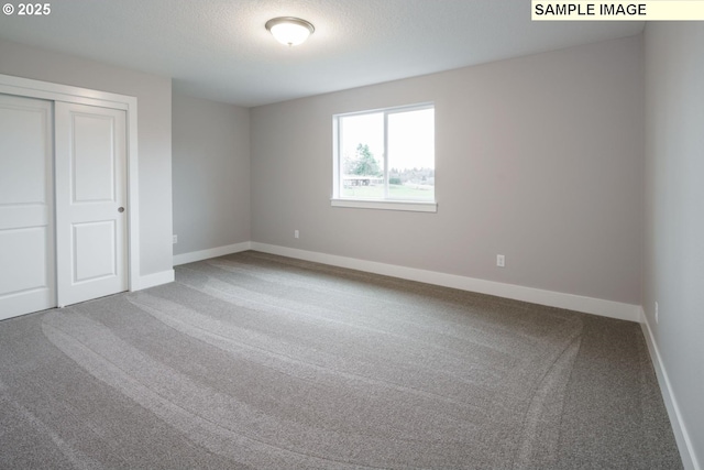 unfurnished bedroom featuring carpet flooring, a textured ceiling, and a closet