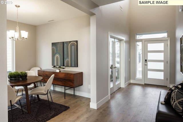 entryway featuring wood-type flooring and a notable chandelier