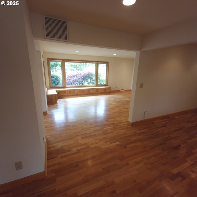 unfurnished room with wood finished floors, baseboards, and recessed lighting