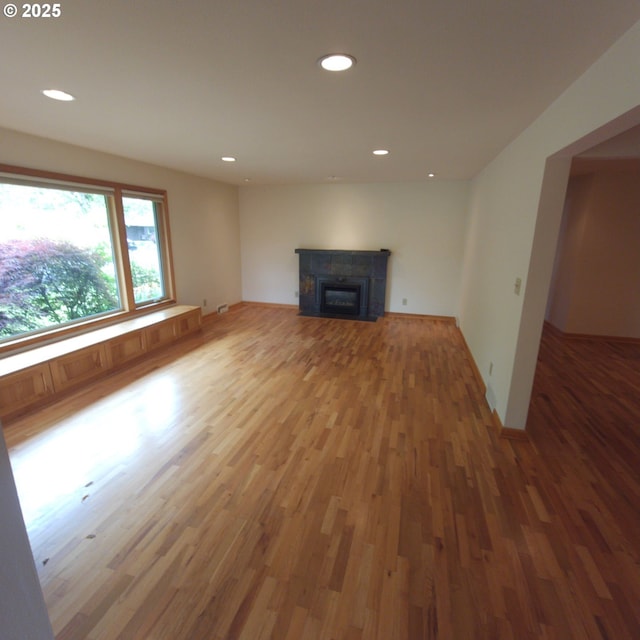 unfurnished living room with light wood-style floors, recessed lighting, and a fireplace