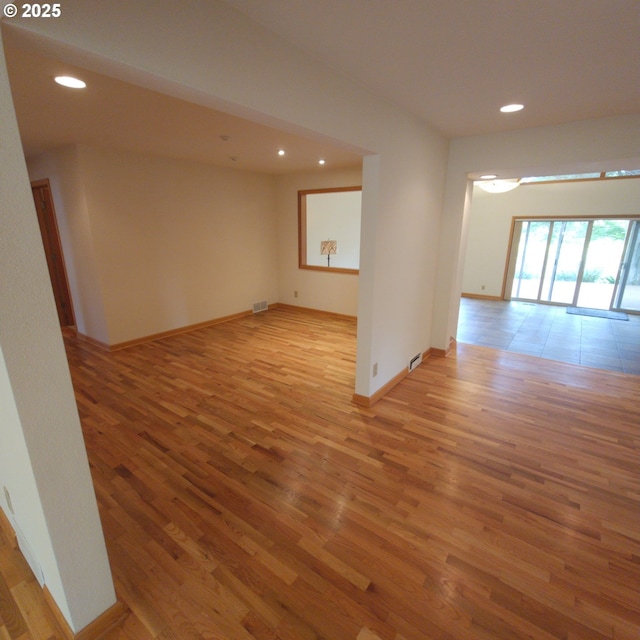 empty room featuring light wood-style floors, recessed lighting, and baseboards