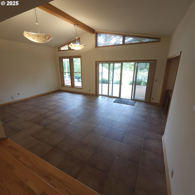 empty room with beam ceiling, high vaulted ceiling, baseboards, and dark tile patterned flooring