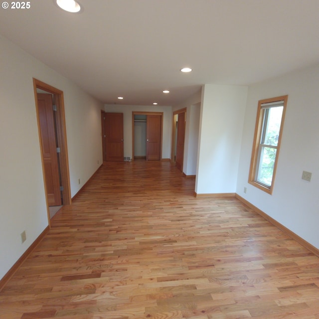 spare room with recessed lighting, light wood finished floors, and baseboards